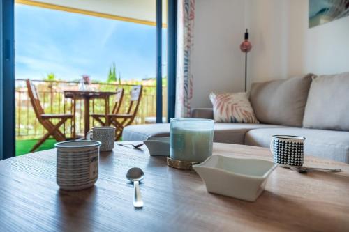 - un salon avec une table et de la vaisselle dans l'établissement Appartement Gaméou - Welkeys, à La Ciotat