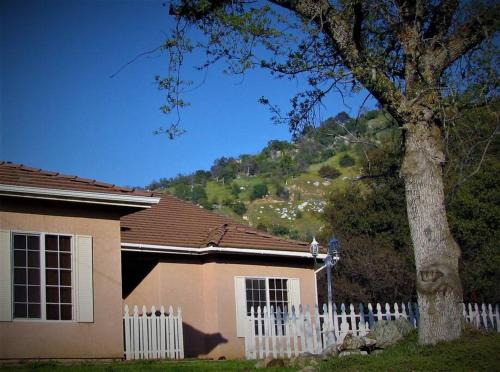a house with a white fence and a tree at Scenic Renovated House, near Sequoia NP in Three Rivers