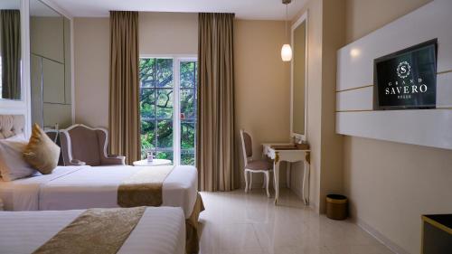 a hotel room with two beds and a window at Grand Savero Hotel Bogor in Bogor