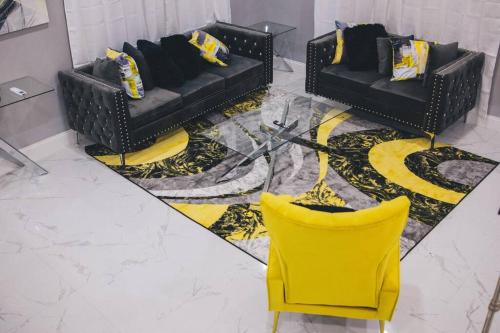 two black couches and a yellow chair in a room at Island Haven Hideaway 5BR in Nassau