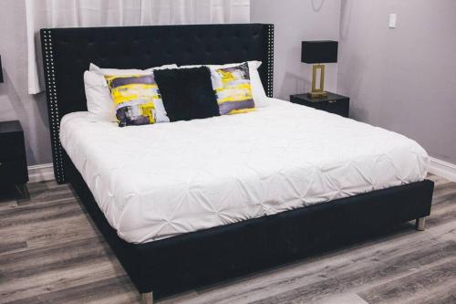 a large bed with a black headboard in a bedroom at Island Haven Hideaway 5BR in Nassau