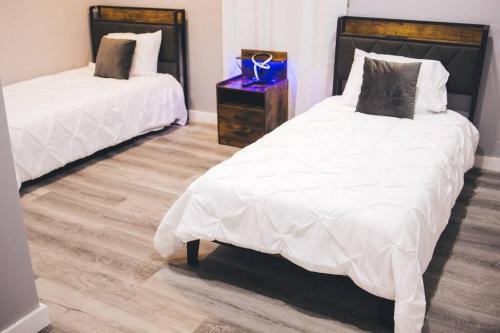 a bedroom with two beds and a wooden floor at Island Haven Hideaway 5BR in Nassau