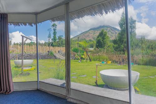 a bathroom with a tub and a view of a yard at Polestay Glamping Kintamani in Kintamani