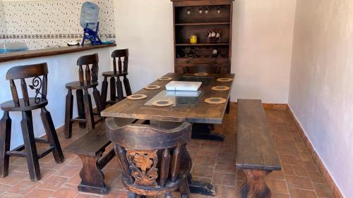 a wooden table in a room with a bar at Linda y Comoda Casa Hospedaje en Barichara in Barichara