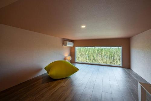 a room with a large yellow object sitting on the floor at THE SECOND Chousei Beach Village平屋ペット不可 in Jōnouchi