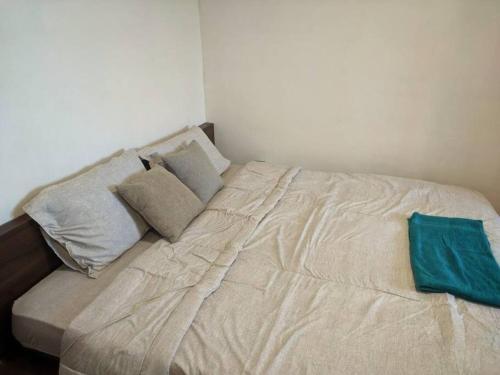 a bed with pillows on it in a bedroom at Relax & Chill 4BR Terrace House in Batam Center