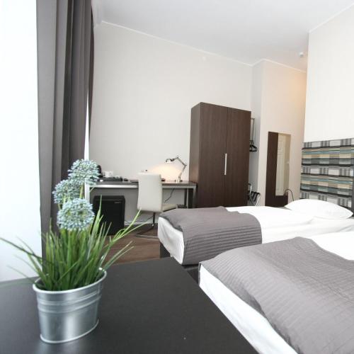 a bedroom with two beds and a desk with a computer at Albergo KOLODZIEJ in Siemianowice Śląskie