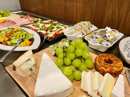 a table topped with cheese and grapes and other appetizers at Best Western Comfort Business Hotel Düsseldorf-Neuss in Neuss