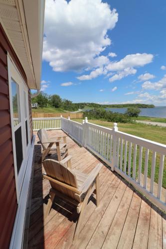 a deck with two wooden chairs on a house at Waterfront House near Pomquet Beach- 2 bedrooms, Pet-Friendly in Antigonish