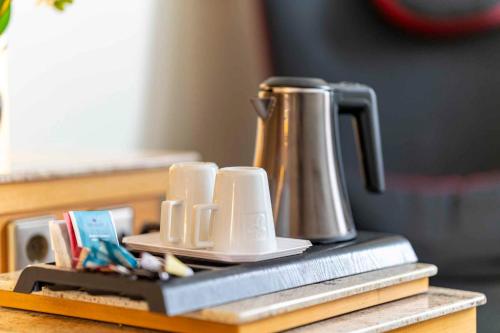 a tea kettle sitting on top of a table at PLAZA INN Blankenburg Ditzingen, Sure Hotel Collection in Ditzingen
