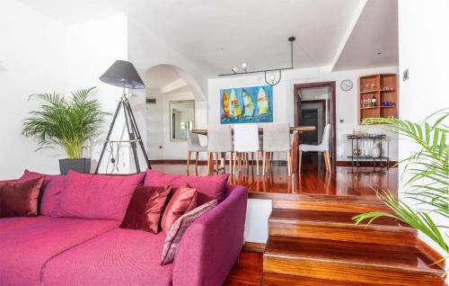 a living room with a purple couch and a dining room at Beach Front Home In Punat With Kitchen in Punat