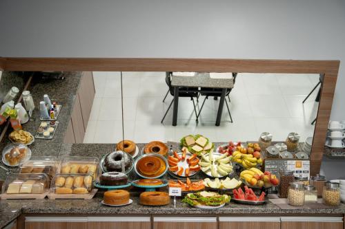 a buffet with many different types of food on a counter at Hotel Home in Lucas do Rio Verde