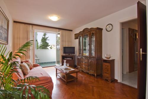 a living room with a couch and a tv at Apartment Tennis in Split