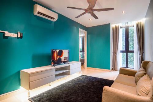 a living room with a blue wall and a tv at H20 Residence Ara Damansara by Airhost in Petaling Jaya