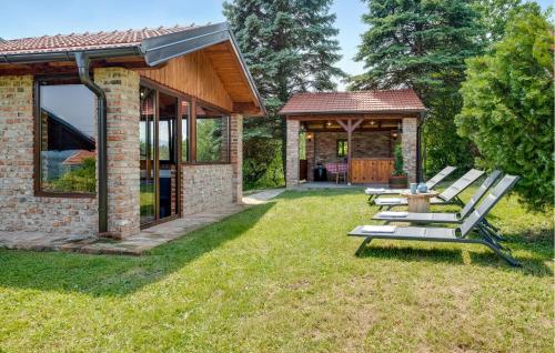 a group of picnic tables in the grass next to a house at Kuca Za Odmor Agata in Banščica
