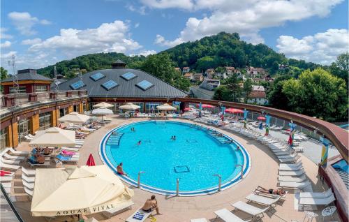 a large swimming pool with chairs and umbrellas at Kuca Za Odmor Agata in Banščica