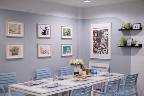 a dining room with a white table and blue chairs at Spacious 4BRTownhouse BTS Onnut 10 Sleeps with Parking in Amphoe Phra Khanong