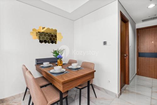 a dining room with a wooden table and chairs at Vista by Kozystay - Alam Sutera in South Tangerang