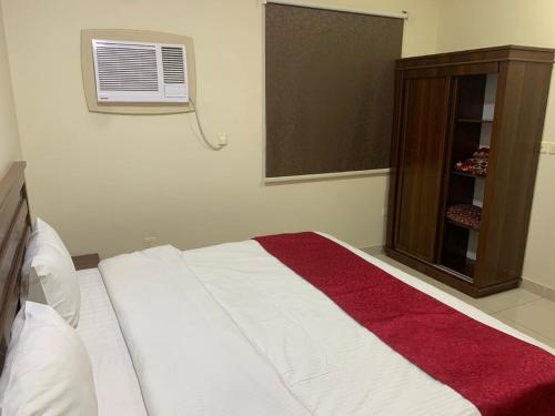 a bedroom with a large bed with a red blanket at شقق ضيافه خاصه 5391 in Yanbu