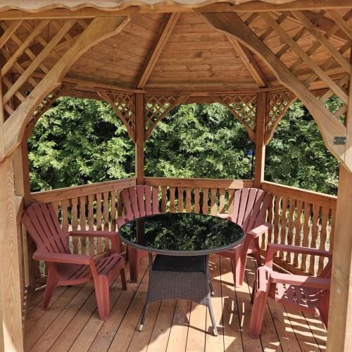 a gazebo with a table and chairs on a deck at Brązowy Domek - Tleń, Bory Tucholskie in Tleń