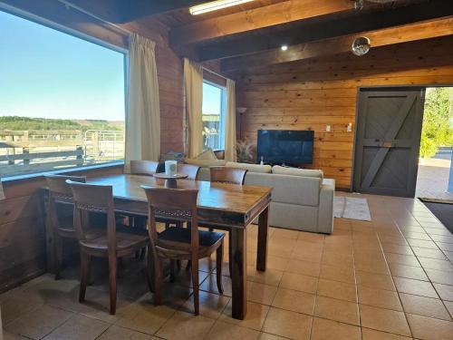 a living room with a table and chairs and a couch at Equestrian Farm Stay in Tahorakuri