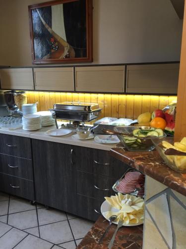 a kitchen with a counter with plates of food on it at Tinódi Fogadó in Sárvár