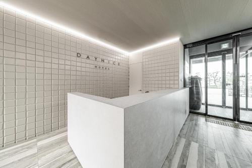 a bathroom with a white tiled wall at Daynice hotel in Boryeong