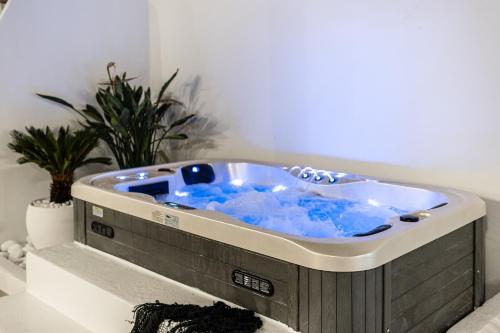 a bath tub with blue water in a room at Yria Traditional House in Vívlos