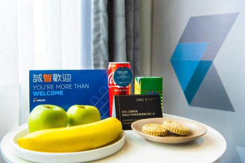 a table with a plate of apples and a plate of food at Holiday Inn Express Macau City Centre by IHG in Macau