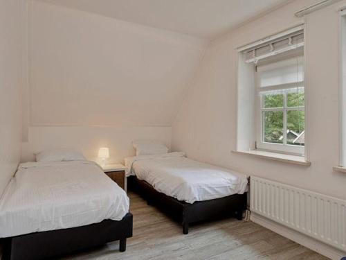 two beds in a white room with a window at Winterswijk Modern retreat in Winterswijk-Meddo