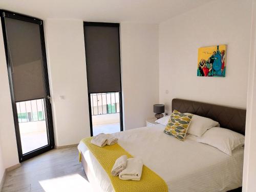 a bedroom with a bed and some windows at Korcula Luxury Apartments in Korčula