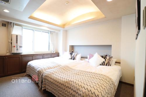 a bedroom with a large bed and a large window at NK BLD4F Sapporo 3LDK 3BR 1 floor 1 room in Sapporo