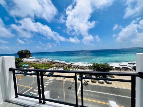 a balcony with a view of the ocean at Rockhand Homestay in Eluan