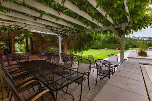 a patio with tables and chairs under a pergola at Penzion Kormorán in Vranov nad Dyjí