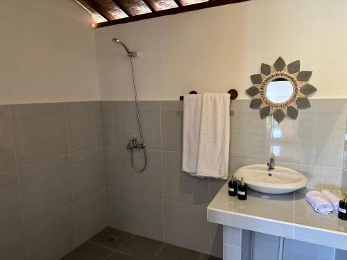 a bathroom with a sink and a mirror at D'Janu Homestay in Sidemen
