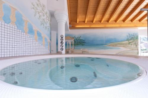 a jacuzzi tub in a room with a painting at Residenz Ambassador in Leukerbad