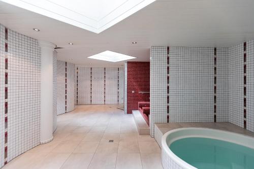 a large bathroom with a tub and a skylight at Residenz Ambassador in Leukerbad
