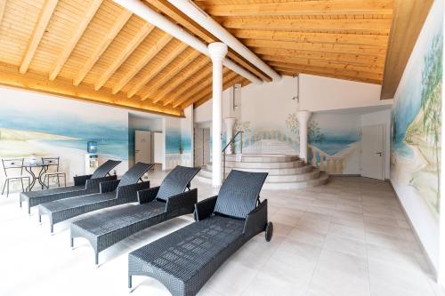a lobby with black chairs and a staircase at Residenz Ambassador in Leukerbad