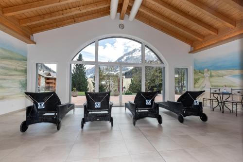 a living room with chairs and a large window at Residenz Ambassador in Leukerbad