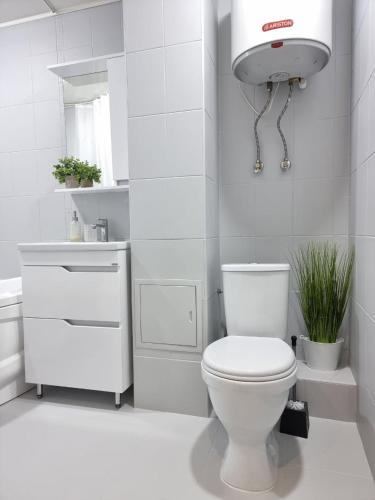 a white bathroom with a toilet and a sink at Идеальная 4-х комн, с домашним уютом и простором in Kostanay