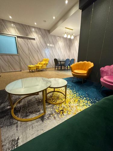 a room with two tables and yellow chairs and a table at Jenny Homestay in Teluk Intan
