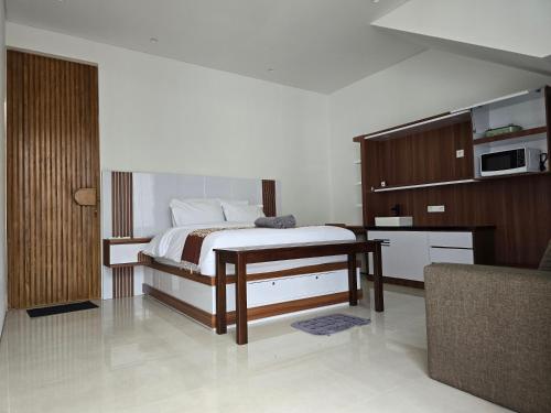 a bedroom with a bed and a kitchen with a microwave at Villa Arturo in Keramas