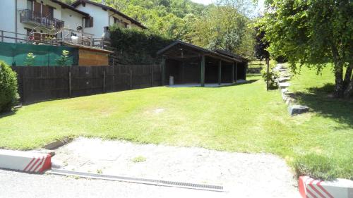 a yard with a fence and a house at B&B Scotty & Co. in Susa