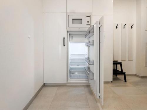 a white kitchen with an open refrigerator with a microwave at Lemon drop in Brno