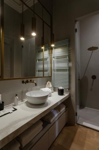 a bathroom with a white sink and a shower at Palazzo Zimara Boutique Hotel in Lecce