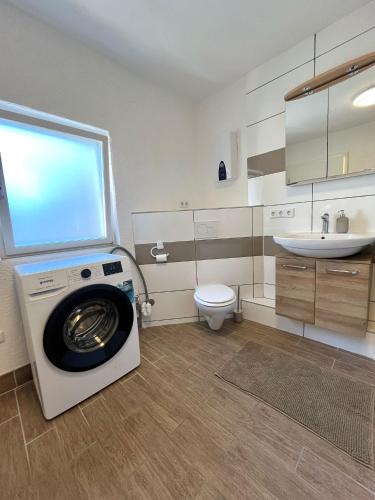 a bathroom with a washing machine and a sink at 90qm Ferienhaus Lorsch in Lorsch