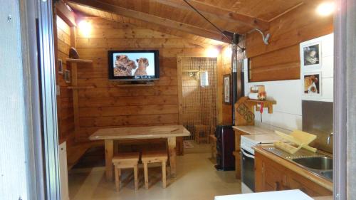 a kitchen with a table and a tv on the wall at B&B Scotty & Co. in Susa