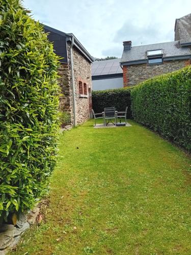 a garden with a bench in the middle of a hedge at Appart Hotel Au Pied de Vigne in Vresse-sur-Semois