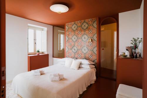 a bedroom with a large bed with white pillows at Palazzo D'Azeglio in Alberobello