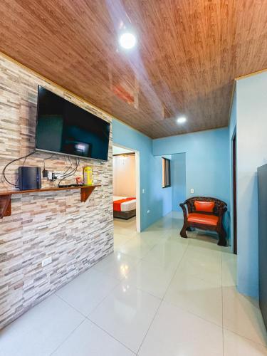 a living room with a tv on a brick wall at La Fortuna Donwtown Dreams in Fortuna
